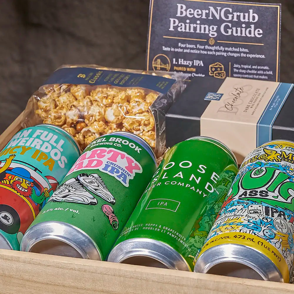 A curated beer pairing gift set arranged in a wooden tray, featuring colorful craft IPA cans, a bag of popcorn, a 'BeerNGrub Pairing Guide' card, and a kraft gift box.