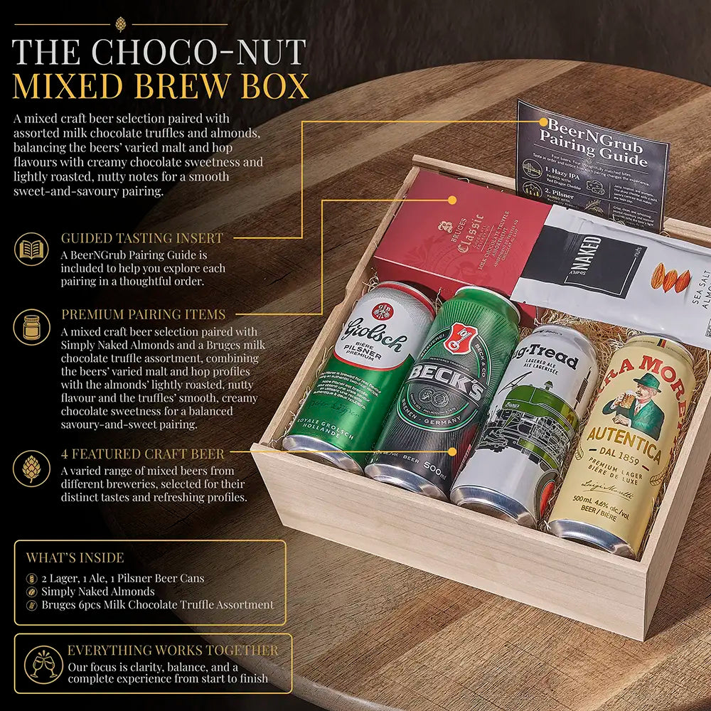 A boxed mixed beer selection displayed on a wooden table. The set includes a choco-nut style selection box with several craft beer cans visible inside, plus included accessories: a Beer/NCrub Pairing Guide, a guided tasting insert card, and a red booklet.