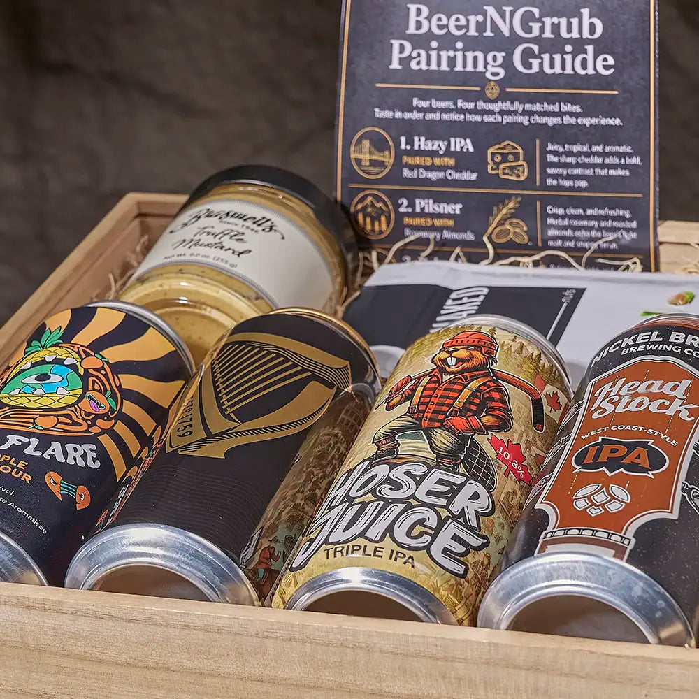 A wooden gift box filled with craft beer cans and a 'BeerNGrub Pairing Guide' booklet. Visible cans include a tiger-striped can labeled 'Flare', a dark can with a harp graphic, a bear-themed triple IPA can, and a brown 'Head Stock' can.
